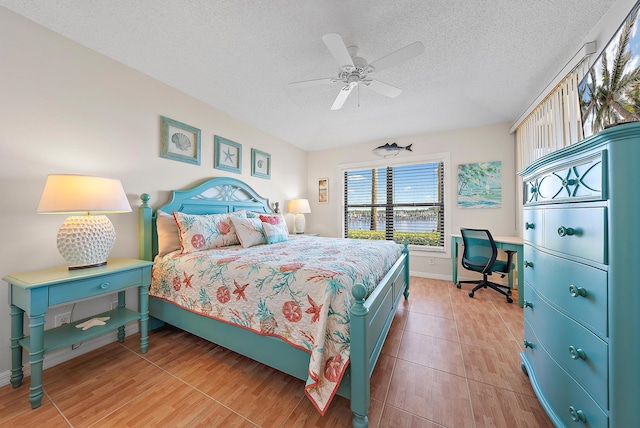 bedroom featuring ceiling fan, wood-type flooring, and a textured ceiling