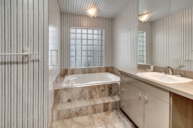 bathroom with vanity and a relaxing tiled tub