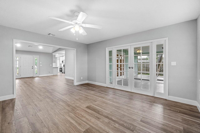 unfurnished living room featuring french doors, ceiling fan, and wood-type flooring