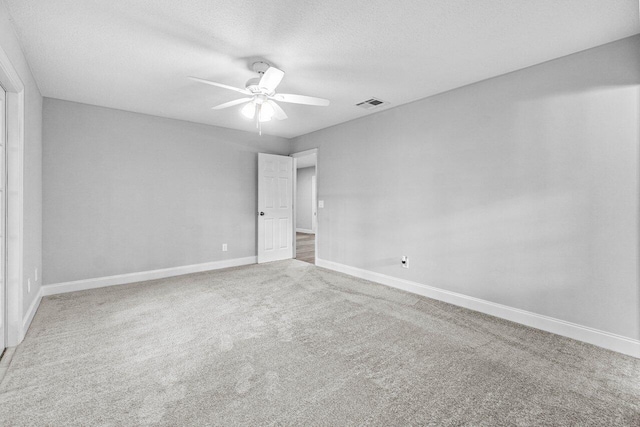 unfurnished room with carpet flooring, ceiling fan, and a textured ceiling