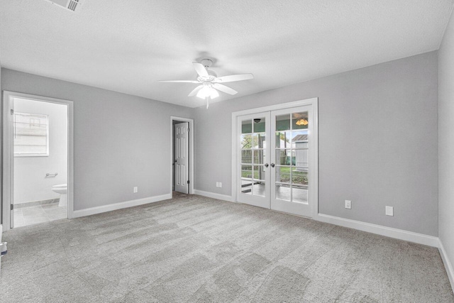 carpeted empty room featuring ceiling fan, french doors, and a textured ceiling