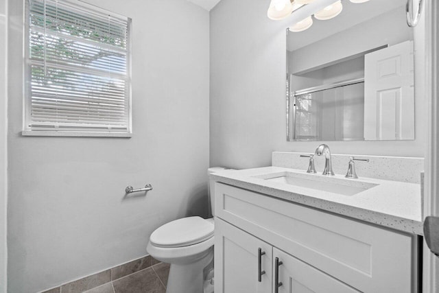 bathroom featuring tile patterned floors, vanity, toilet, and walk in shower