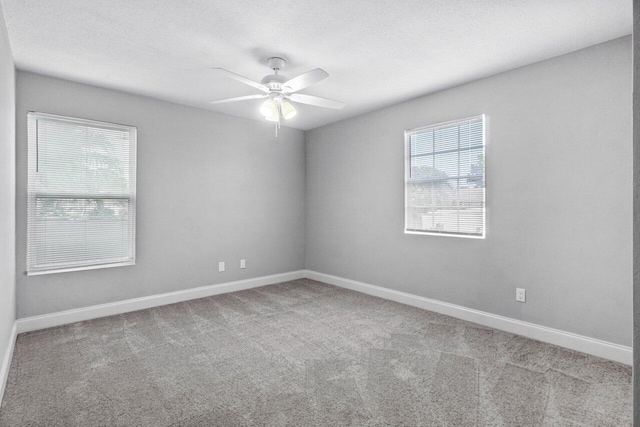 empty room featuring light carpet, plenty of natural light, and ceiling fan