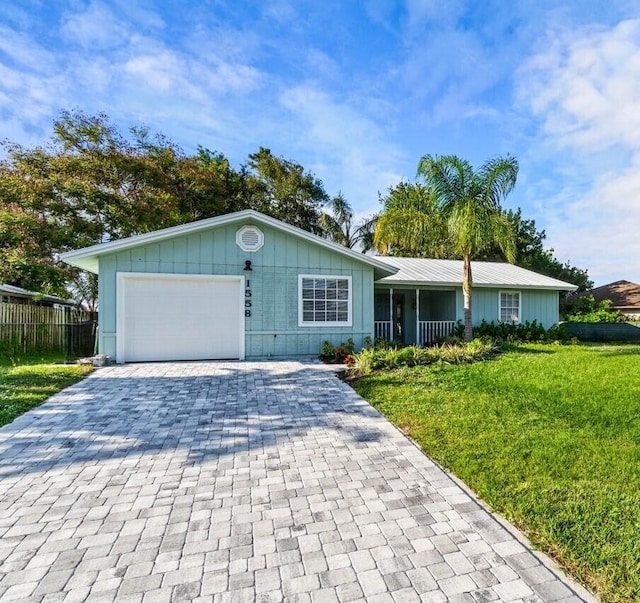 ranch-style home featuring covered porch, a garage, and a front lawn