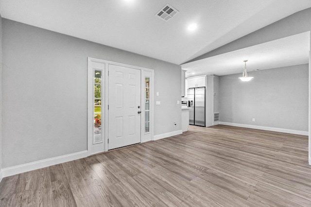 foyer entrance featuring light wood-type flooring and lofted ceiling