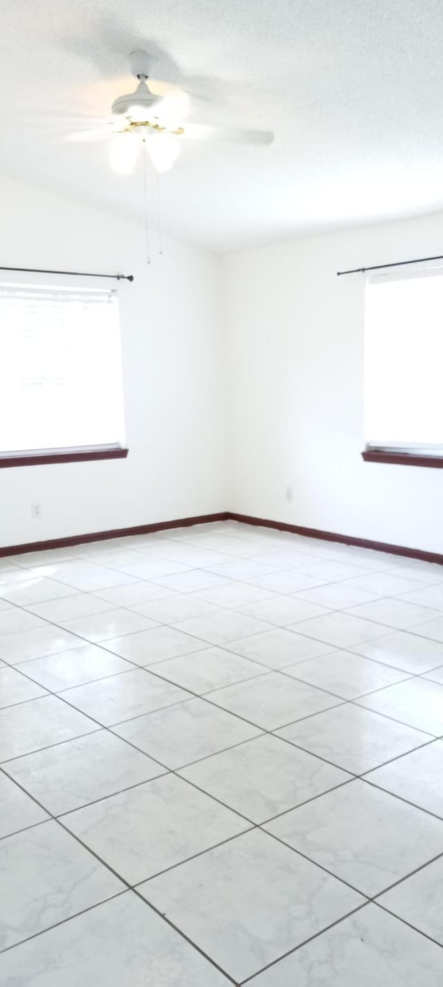 tiled empty room featuring a healthy amount of sunlight