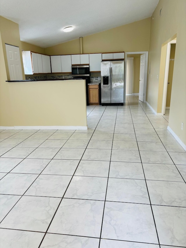 kitchen with lofted ceiling and appliances with stainless steel finishes