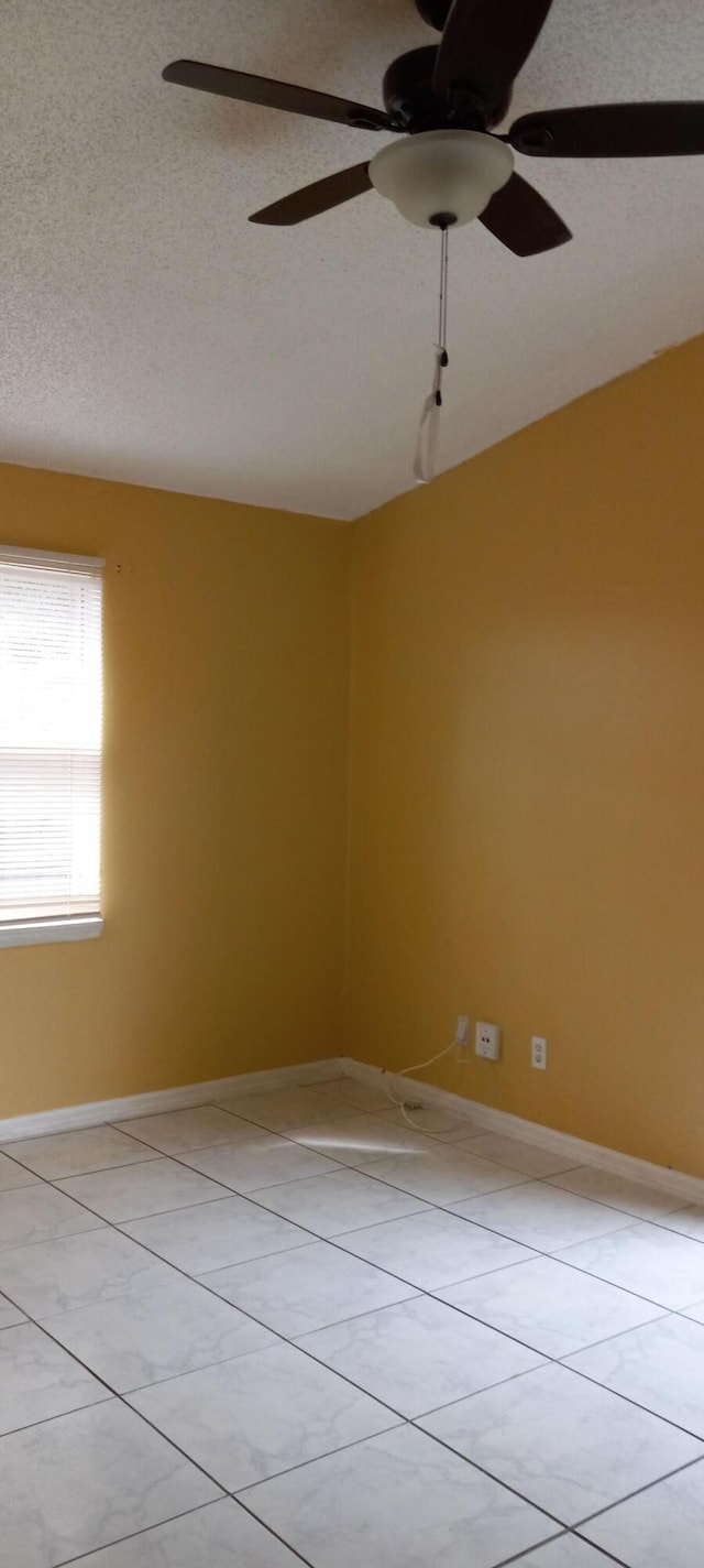 tiled spare room featuring ceiling fan and a textured ceiling