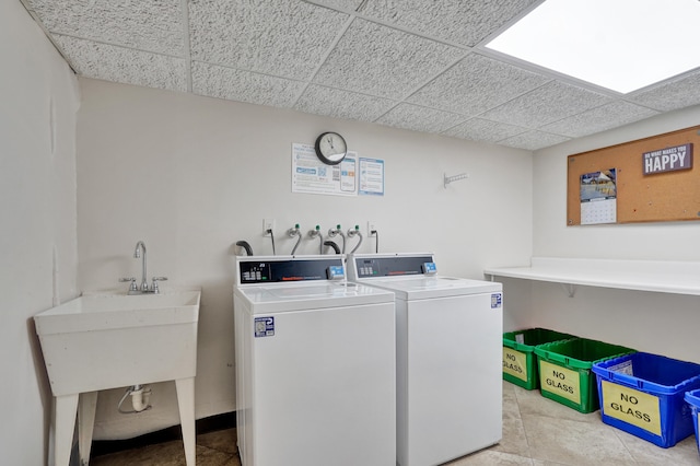 washroom featuring light tile patterned floors, sink, and washing machine and clothes dryer