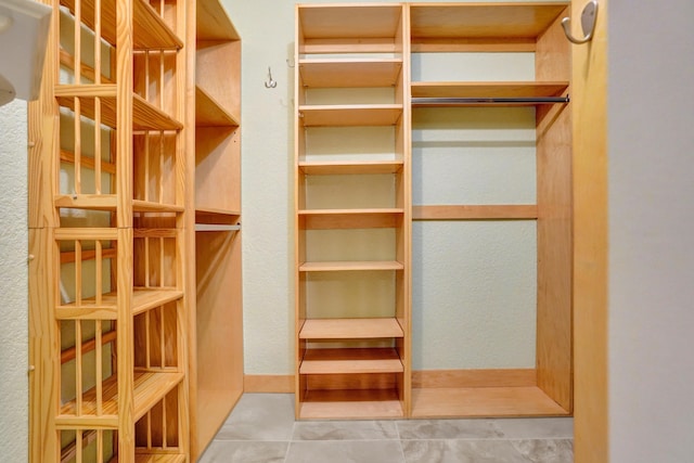 walk in closet with light tile patterned floors