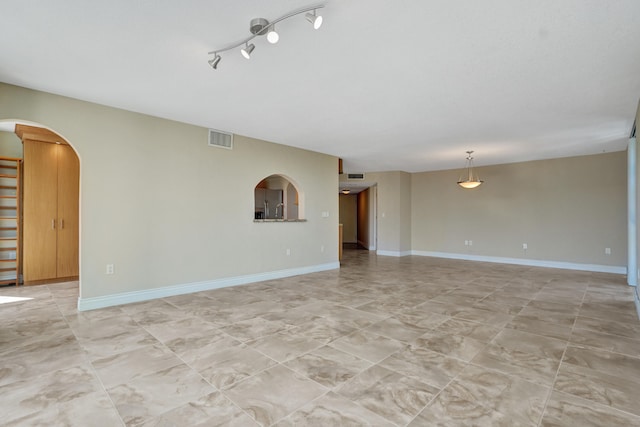 unfurnished living room with rail lighting