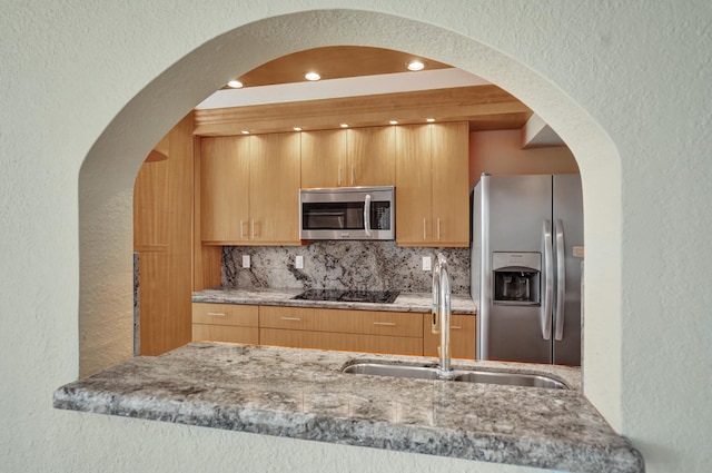 kitchen featuring decorative backsplash, light brown cabinetry, stainless steel appliances, and sink