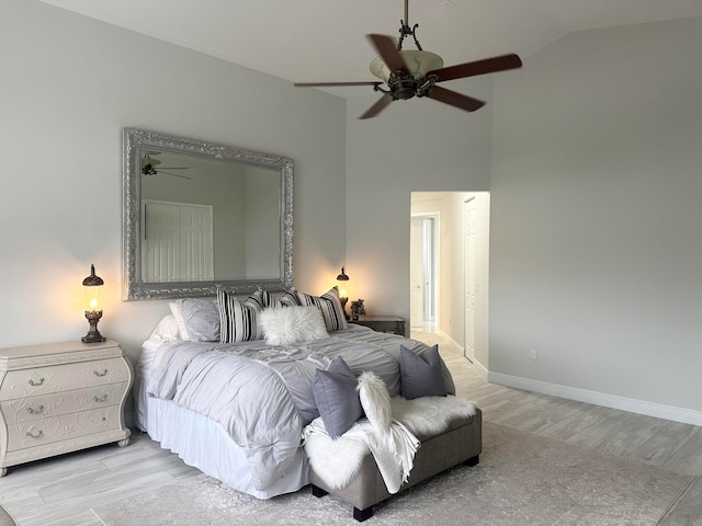 bedroom with ceiling fan, light wood-type flooring, and vaulted ceiling