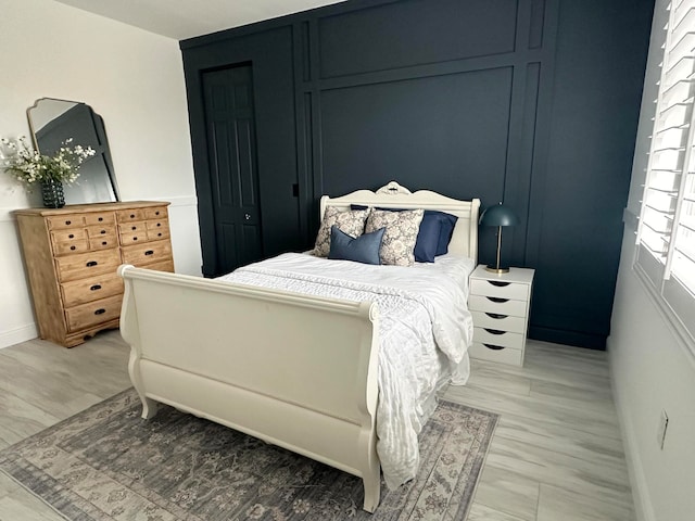 bedroom with light hardwood / wood-style floors and a closet