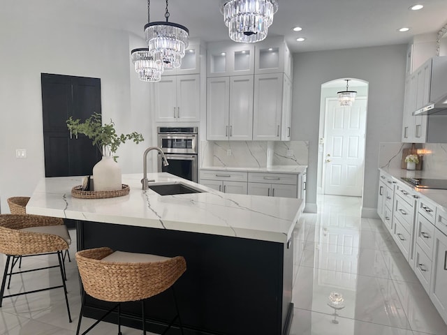 kitchen with sink, decorative light fixtures, stainless steel double oven, and backsplash