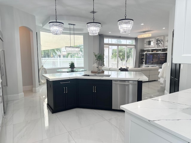 kitchen featuring light stone countertops, hanging light fixtures, sink, white cabinets, and dishwasher