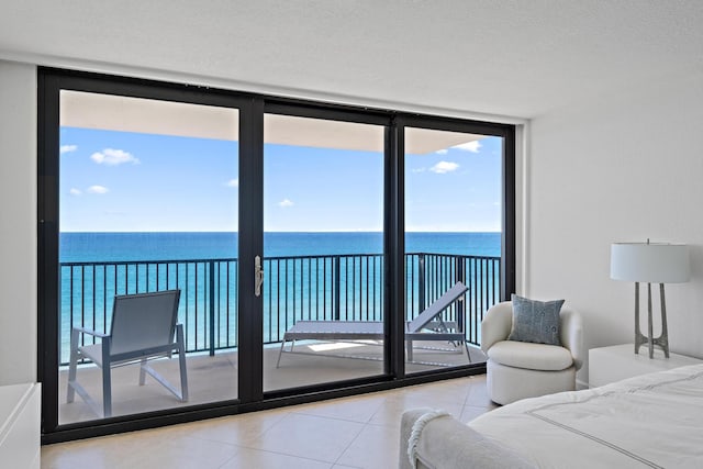 bedroom featuring expansive windows, access to outside, multiple windows, and tile patterned flooring