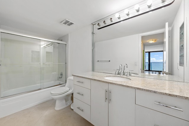 bathroom with visible vents, toilet, shower / bath combination with glass door, tile patterned flooring, and vanity