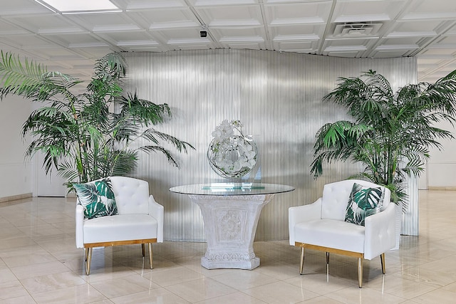 living area with metal wall and tile patterned floors