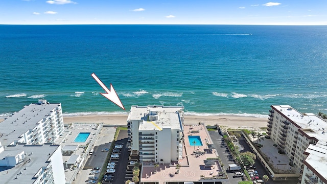 birds eye view of property featuring a water view and a beach view