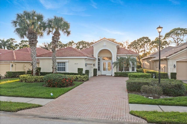 mediterranean / spanish-style house with french doors and a front yard