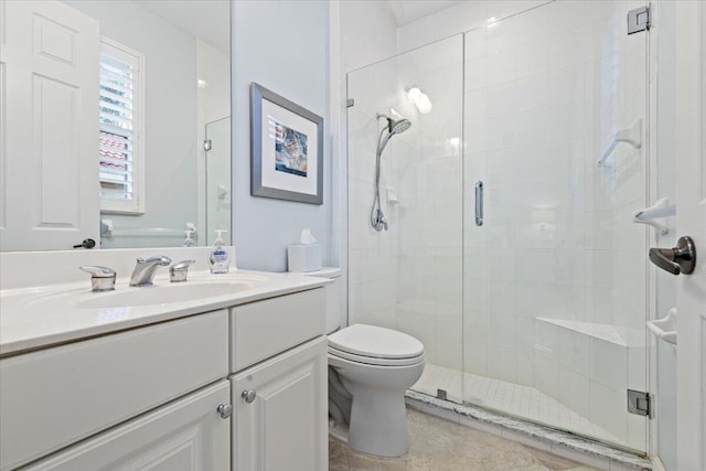 bathroom featuring vanity, a shower with shower door, and toilet