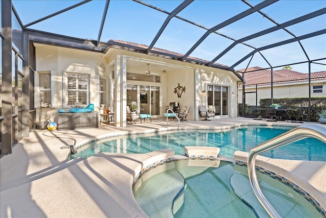 view of swimming pool featuring an in ground hot tub, a patio, ceiling fan, and a lanai