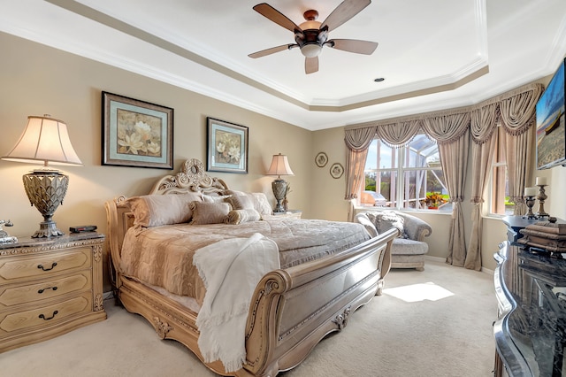 carpeted bedroom featuring ceiling fan, ornamental molding, and a tray ceiling