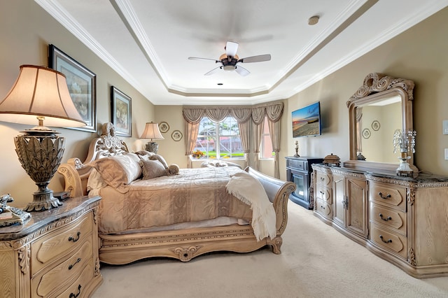 carpeted bedroom featuring a tray ceiling, ceiling fan, and ornamental molding