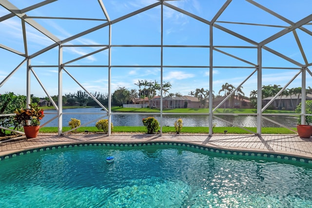 view of swimming pool with glass enclosure and a water view