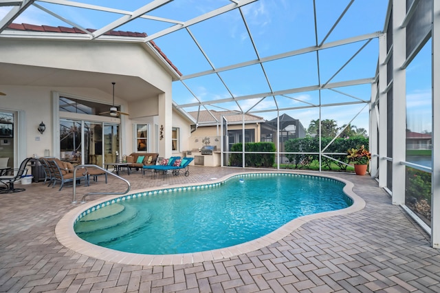 view of swimming pool with glass enclosure, ceiling fan, an outdoor living space, and a patio