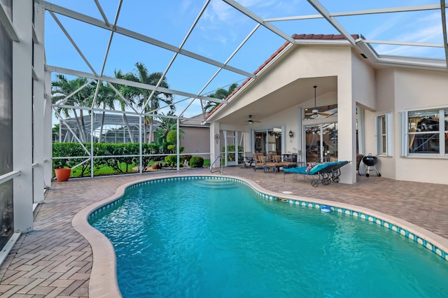 view of swimming pool featuring a lanai, a patio area, and ceiling fan