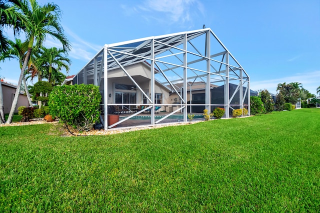 back of property with a lawn and glass enclosure