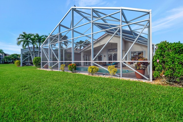 rear view of property featuring glass enclosure and a yard