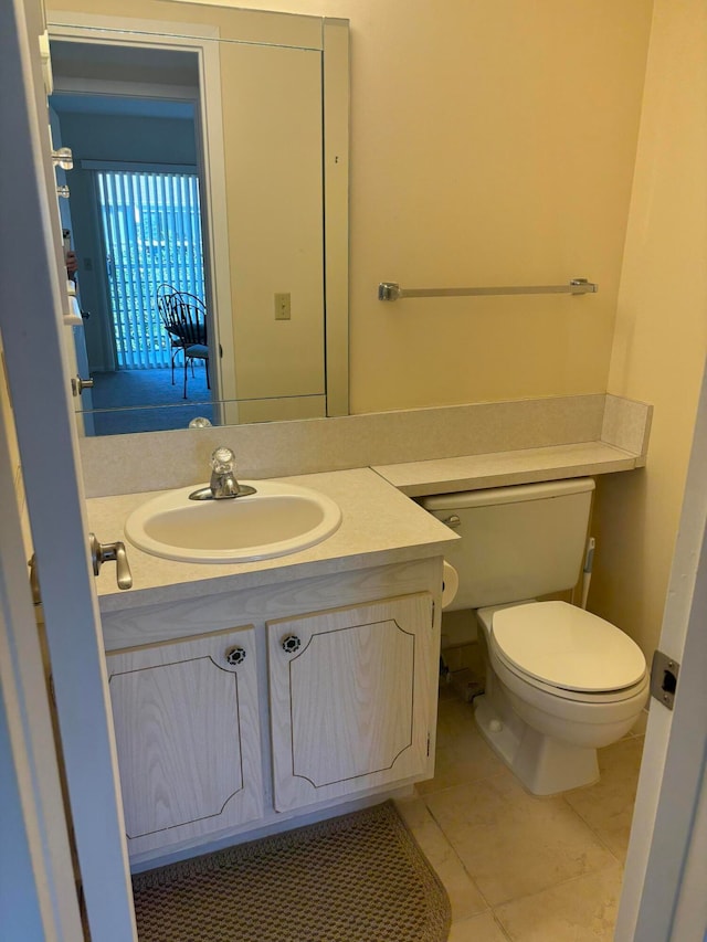 bathroom with tile patterned flooring, vanity, and toilet