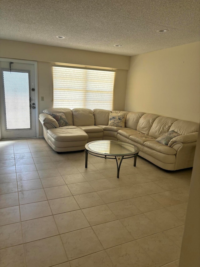 living room featuring light tile patterned flooring and a textured ceiling