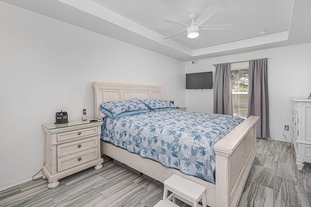 bedroom featuring ceiling fan and a tray ceiling