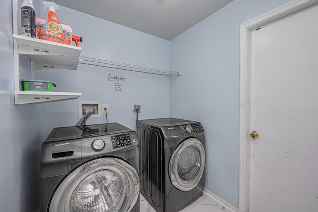 clothes washing area with a textured ceiling and separate washer and dryer