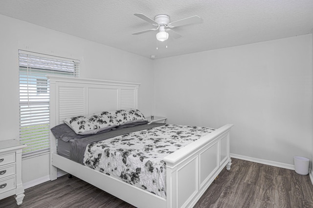 bedroom with ceiling fan, dark hardwood / wood-style flooring, multiple windows, and a textured ceiling