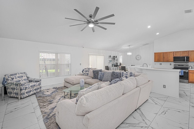 living room featuring ceiling fan, lofted ceiling, and sink