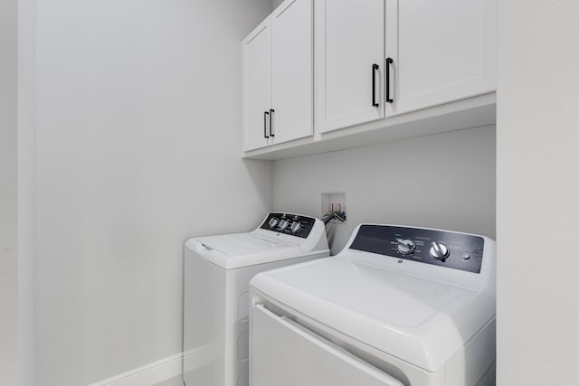 washroom with cabinets and washing machine and clothes dryer