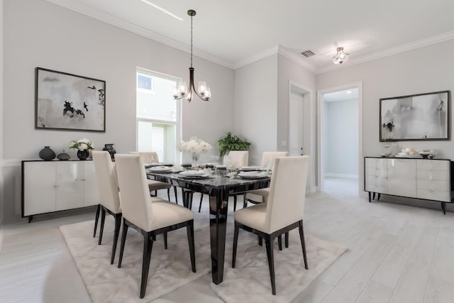 dining room featuring an inviting chandelier, light hardwood / wood-style floors, and ornamental molding