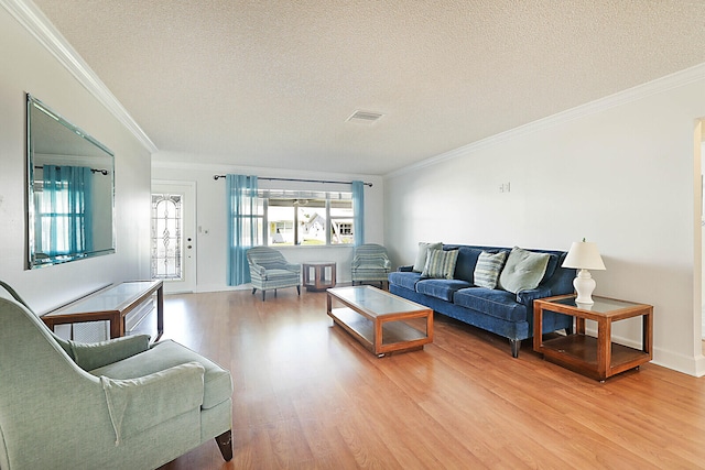 living room with light wood-type flooring, a textured ceiling, and crown molding