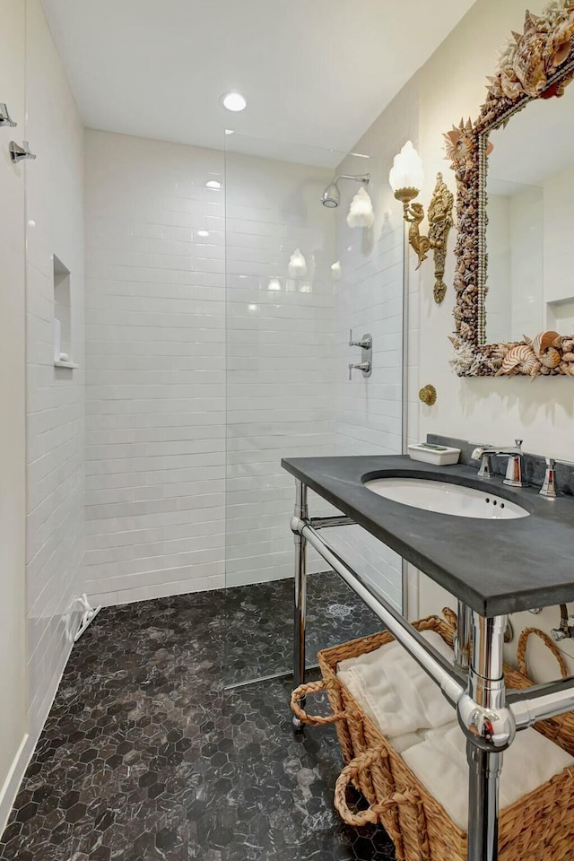 bathroom with tiled shower and sink