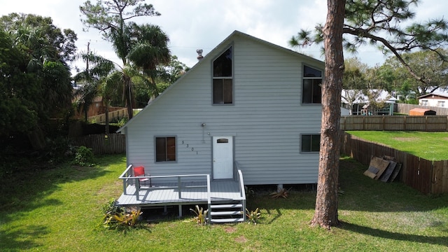 rear view of property with a yard and a wooden deck