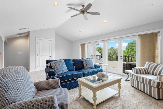 carpeted living room with a textured ceiling, ceiling fan, french doors, and vaulted ceiling