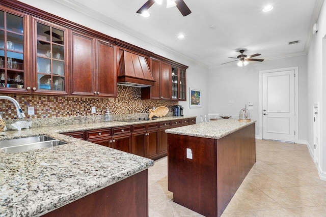 kitchen with tasteful backsplash, a kitchen island, ornamental molding, and sink