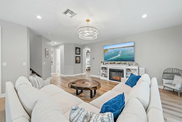 living room with light hardwood / wood-style floors and a chandelier