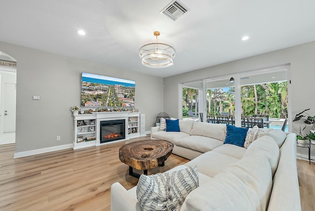 living room with a chandelier and light hardwood / wood-style flooring