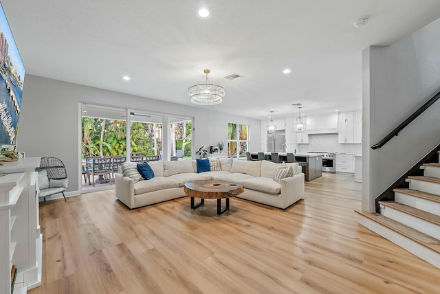 living room with light hardwood / wood-style flooring and a chandelier